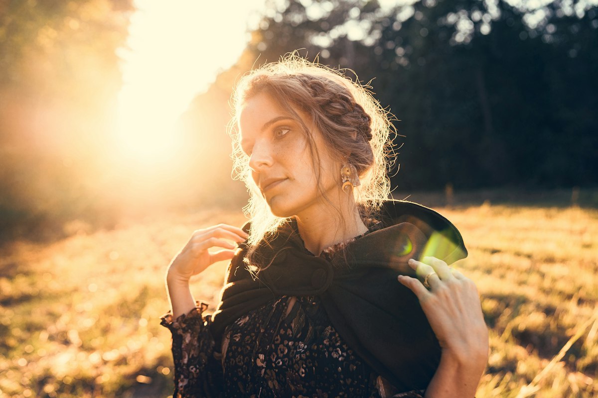 A woman standing in a sunlit golden field