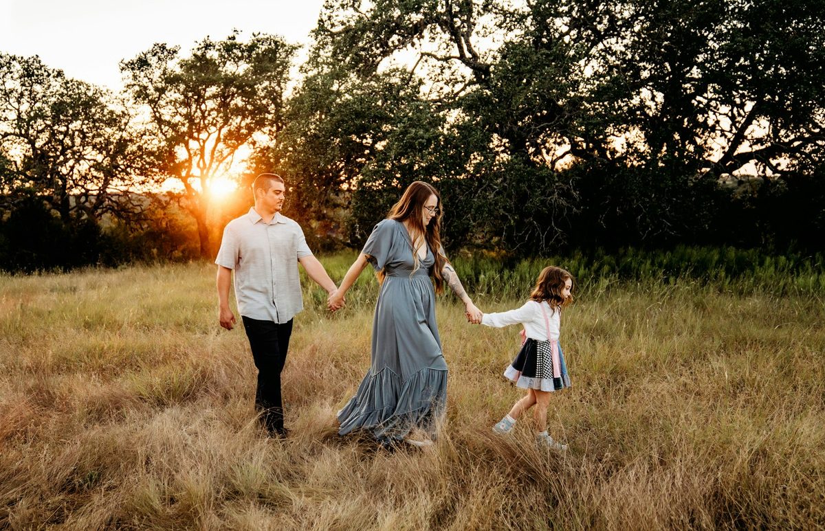A family walking hand in hand through a golden field